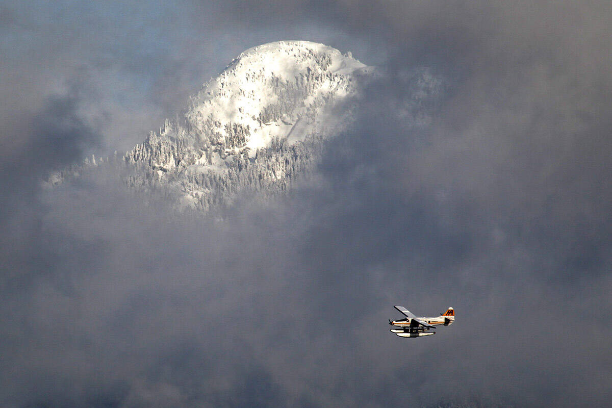 The snow-covered top of Mount Seymour is visible through low cloud as a Harbour Air floatplane approaches Vancouver, B.C., on Tuesday December 28, 2010. THE CANADIAN PRESS/Darryl Dyck