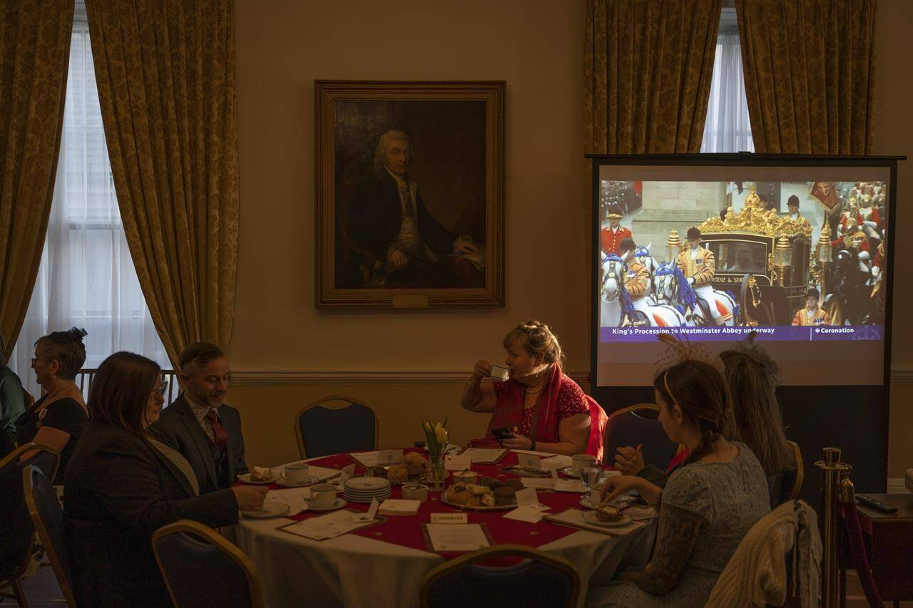 People drink tea and eat pastries during an early-morning viewing party of the coronation of King Charles III at Government House in Halifax on Saturday, May 6, 2023. THE CANADIAN PRESS/Darren Calabrese