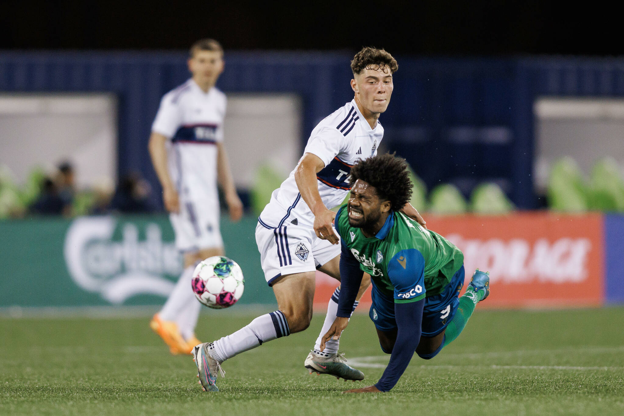 York United FC forward Brian Wright (9) tumbles as he battles for the ball with Vancouver Whitecaps midfielder Sebastian Berhalter (16) during the second half of Canadian Championship quarterfinal soccer game in Toronto on Wednesday, May 10, 2023. THE CANADIAN PRESS/Cole Burston