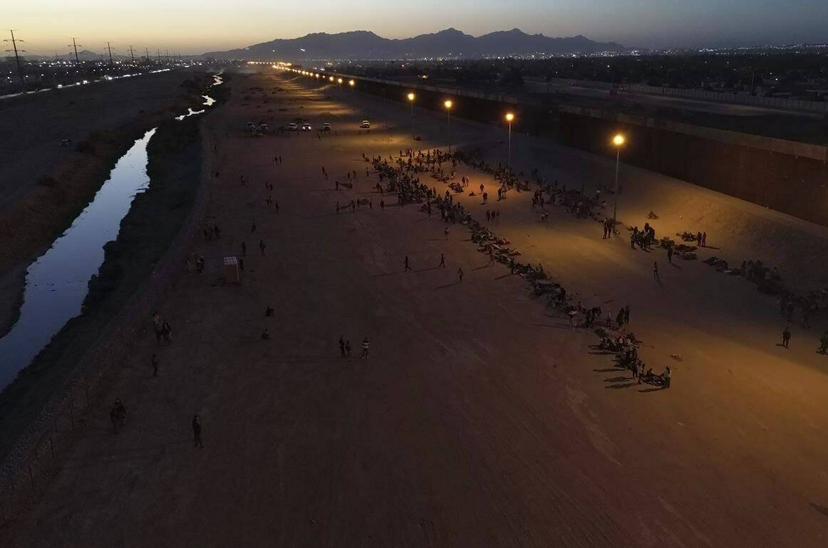 Migrants wait for U.S. authorities, between a barbed-wire barrier and the border fence at the US-Mexico border, as seen from Ciudad Juarez, Mexico, Wednesday, May 10, 2023. THE CANADIAN PRESS/AP-Christian Chavez