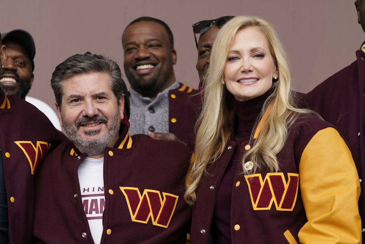 FILE - Dan and Tanya Snyder, co-owner and co-CEOs of the Washington Commanders, pose for photos after unveiling their NFL football team's new identity, Wednesday, Feb. 2, 2022, in Landover, Md. Dan Snyder has an agreement in principle to sell the Washington Commanders to a group led by Josh Harris and Mitchell Rales that includes Magic Johnson for a North American professional sports team record $6.05 billion. (AP Photo/Patrick Semansky, File)