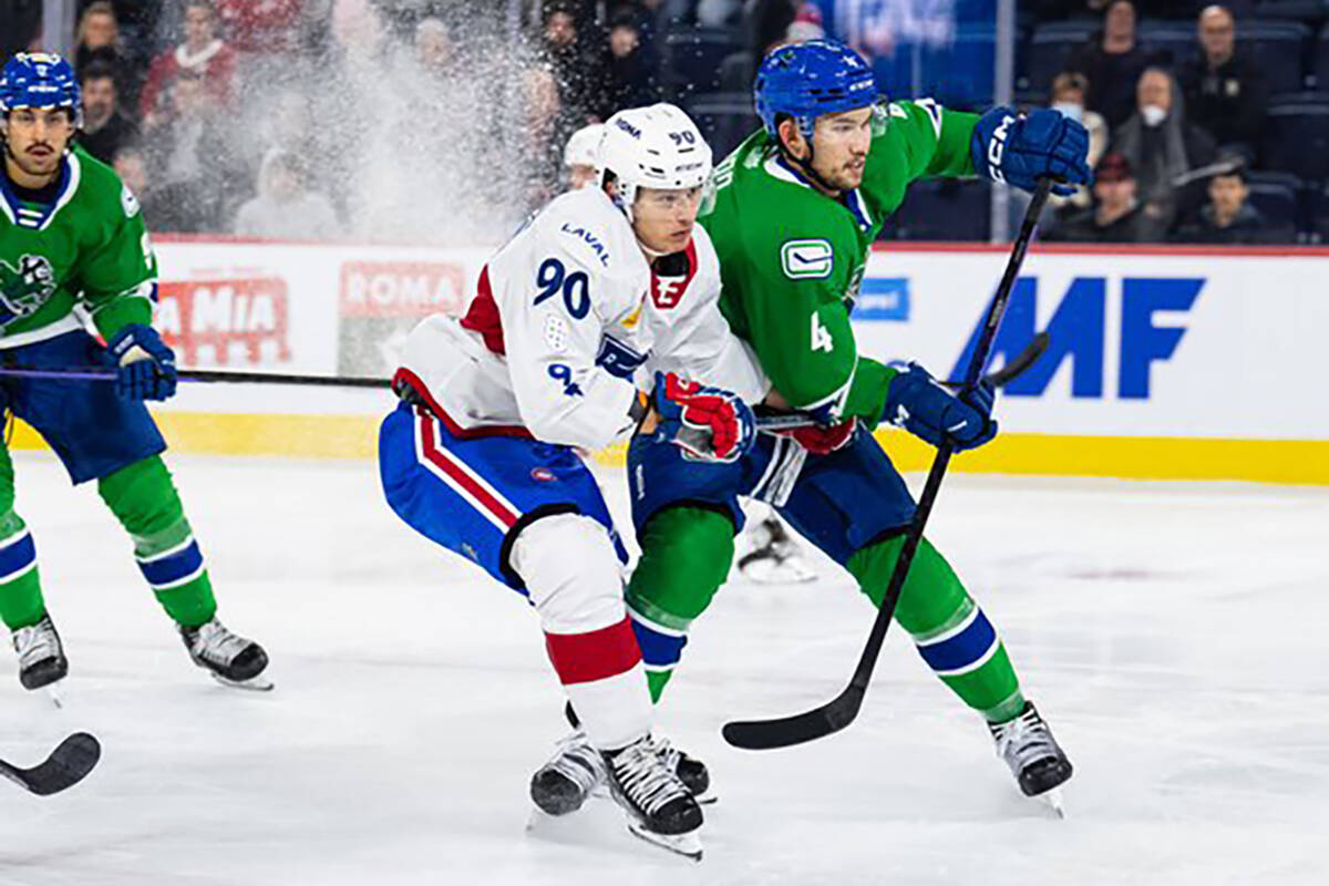 Abbotsford’s Jett Woo checks Laval’s Anthony Richard during AHL action on Wednesday (Nov. 16). (Abbotsford Canucks photo)
