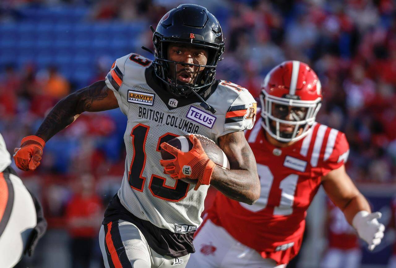 B.C. Lions wide receiver Dominique Rhymes, left, runs the ball as Calgary Stampeders defensive linemen Isaac Adeyemi-Berglund chases him during first half CFL football action in Calgary, Thursday, June 8, 2023.THE CANADIAN PRESS/Jeff McIntosh