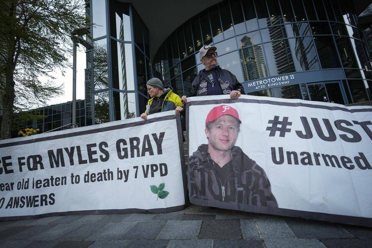 Protesters hold banners with a photograph of Myles Gray, who died following a confrontation with several police officers in 2015, before the start of a coroner’s inquest into his death, in Burnaby, B.C. April 17, 2023. On May 1, the jury released three recommendations with two directed at the Vancouver police department: to expedite the use of body cameras for all patrol officers and to “review and enhance” the crisis de-escalation and containment training that officers receive. THE CANADIAN PRESS/Darryl Dyck