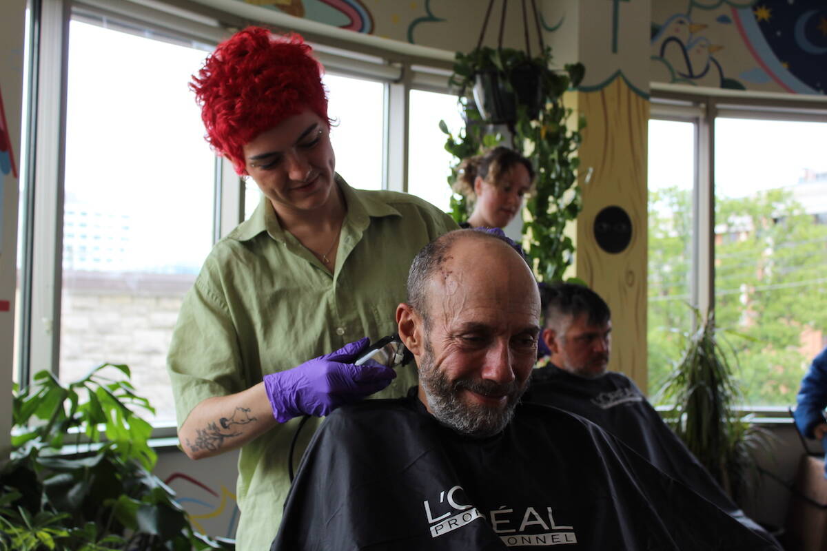 The Natural Hair Salon stylist Emilya Blegun gives David, an Our Place participant, a haircut for Handsome Day. (Natasha Baldin/News)