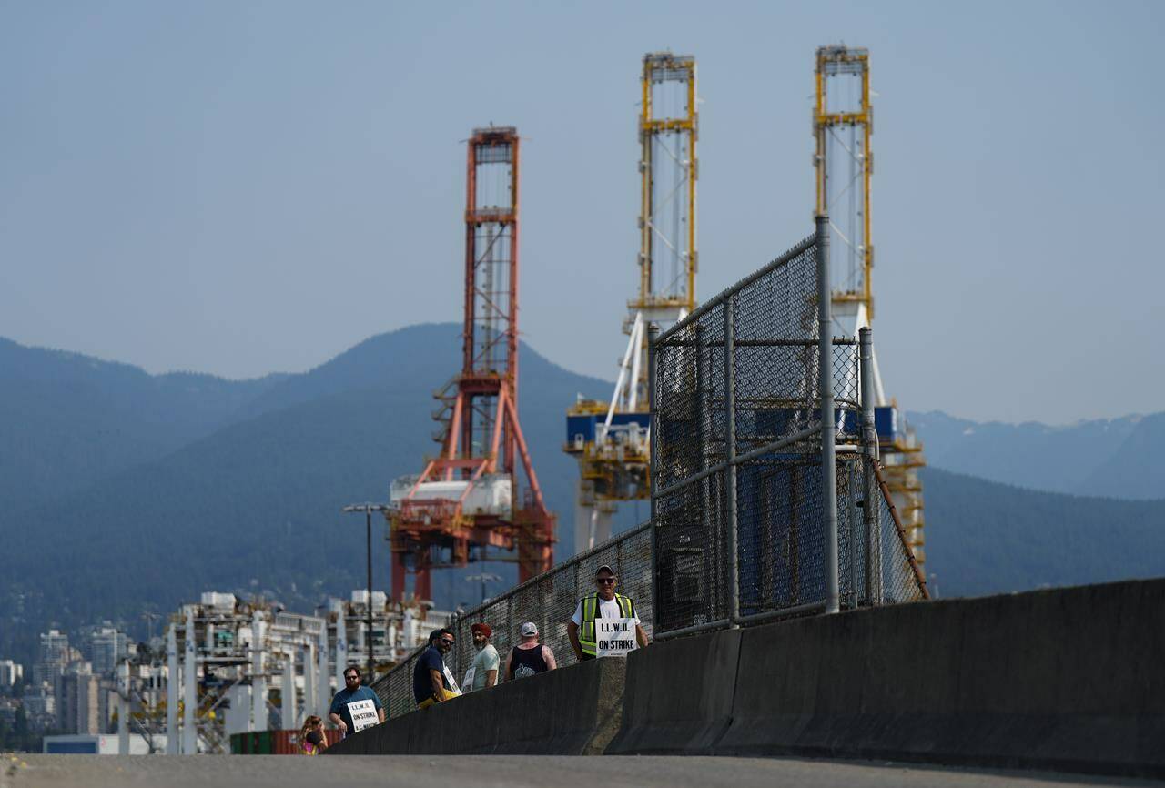 Striking International Longshore and Warehouse Union Canada workers picket at a port entrance in Vancouver, B.C., Tuesday, July 4, 2023. Talks between maritime employers and the union representing British Columbia port workers remain deadlocked over maintenance issues as a strike by the workers enters its fifth day. THE CANADIAN PRESS/Darryl Dyck