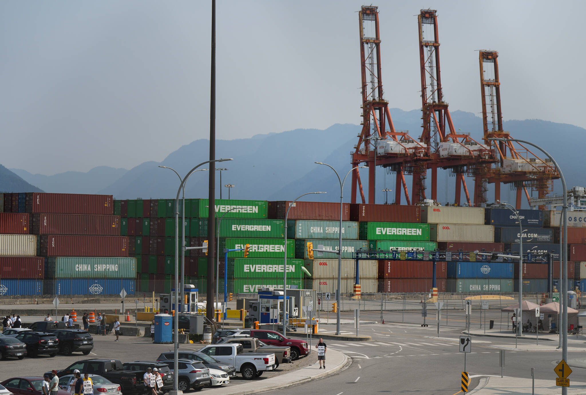 Striking International Longshore and Warehouse Union Canada workers picket at a port entrance in Vancouver, B.C., Tuesday, July 4, 2023. The strike at more than 30 British Columbia ports entered its fifth day on Wednesday after 7,400 port workers walked off the job on the weekend. THE CANADIAN PRESS/Darryl Dyck