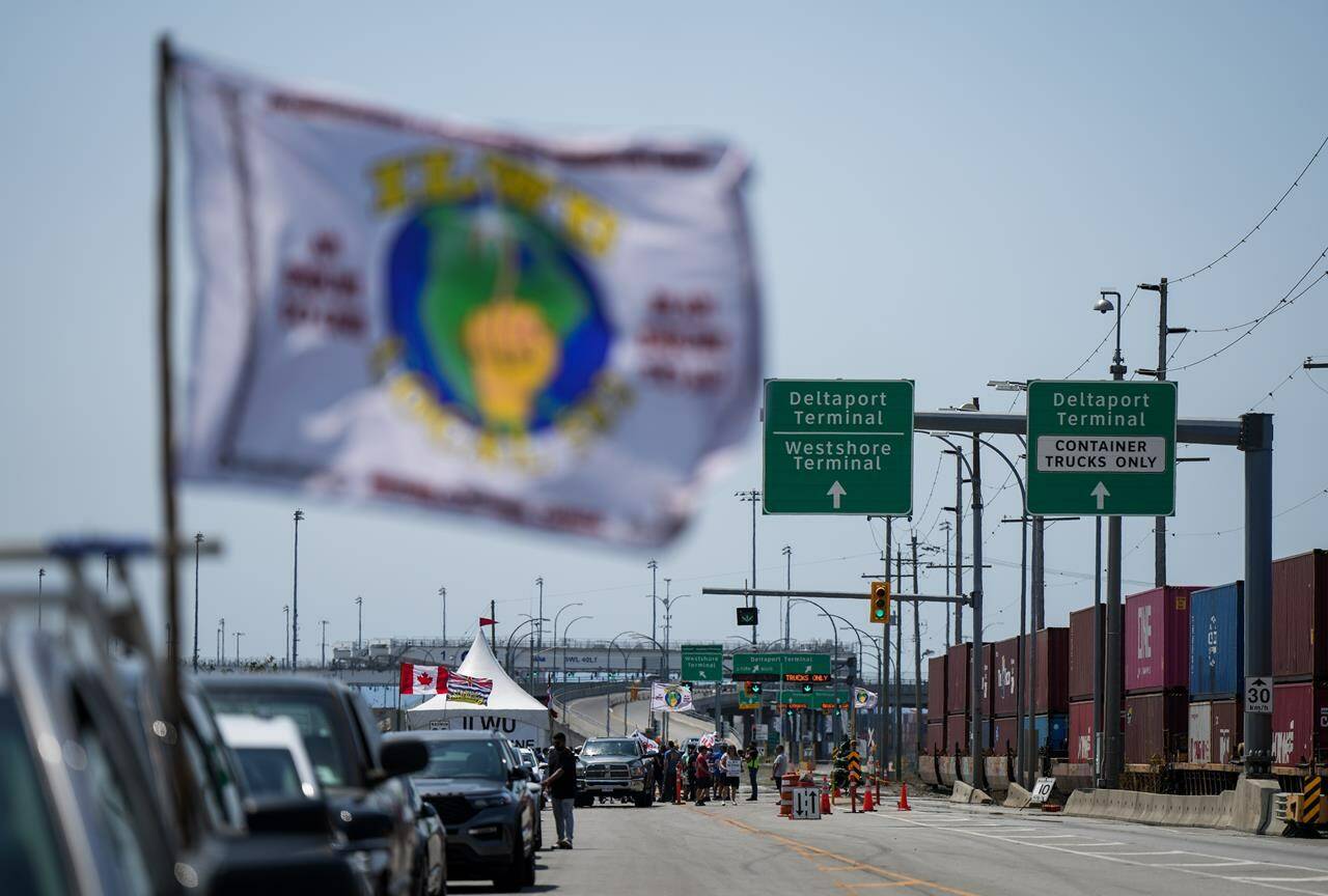 Striking International Longshore and Warehouse Union Canada workers picket at the entrance to Deltaport, in Delta, B.C., on Friday, July 7, 2023. A rally in Vancouver is scheduled for today as the strike at British Columbia’s ports stretches into its second week. THE CANADIAN PRESS/Darryl Dyck