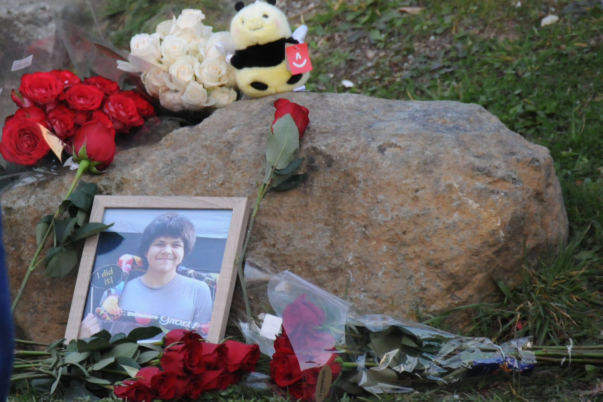 A photo of Clifton Johnston is placed against a rock in front of the Port Alberni Friendship Center during a candlelight vigil for the young man. (SUSAN QUINN/Alberni Valley News)