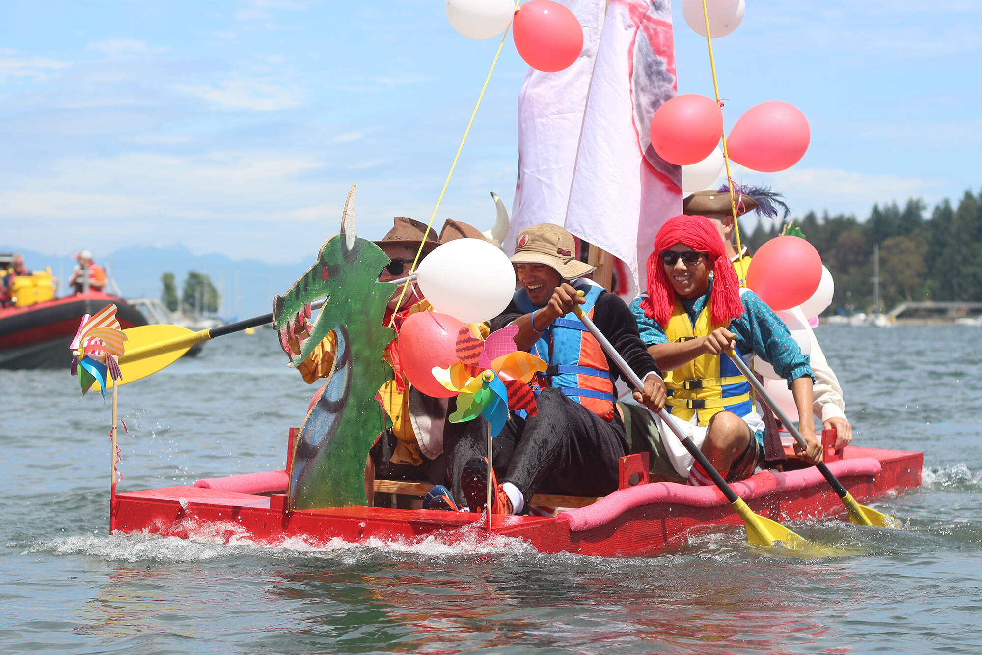 The Island Red Cedar Construction team, including paddlers Ben Skinner, front, and Logan Breuker, near the shore at the Silly Boat Regatta on Sunday, July 16. (Greg Sakaki/News Bulletin)
