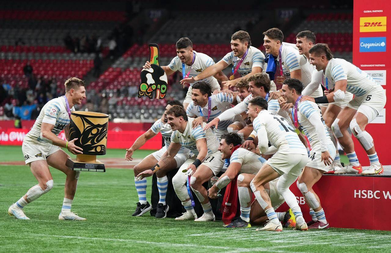 Argentina’s Matias Osadczuk, left, brings the trophy to his teammates as they celebrate after defeating France during gold medal HSBC Canada Sevens rugby action, in Vancouver on March 4, 2023. Vancouver has made the cut in the rebranded and slimmed-down World Rugby Sevens Series. The new format features eight events, each offering men’s and women’s play, under the HSBC SVNS name. THE CANADIAN PRESS/Darryl Dyck