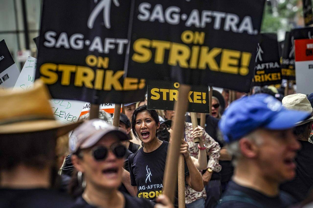 Striking writers and actors chant as they walk a picket line, Friday July 14, 2023, at NBC Universal Studios in New York. The picketing comes a day after the main actors union voted to join screenwriters in a double-barreled strike for the first time in more than six decades. The dispute immediately shut down production across the entertainment industry after talks for a new contract with studios and streaming services broke down. (AP Photo/Bebeto Matthews)