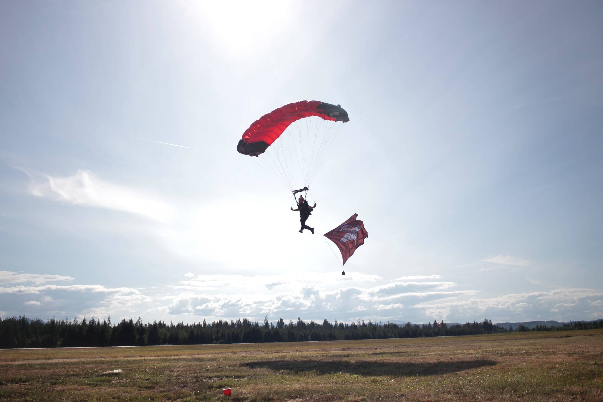 Darryl Cattell flies the Operation Pegasus Jump flag into the drop zone. Photo by Marc Kitteringham/Campbell River Mirror
