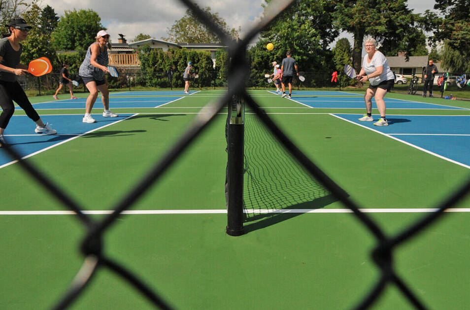People play pickleball on the courts at Kinsmen Park in Chilliwack on Tuesday, May 25, 2021. In the background you can see the house where the Dhawan family lives. They say the noise from the courts is ruining their lives. (Jenna Hauck/ Chilliwack Progress)