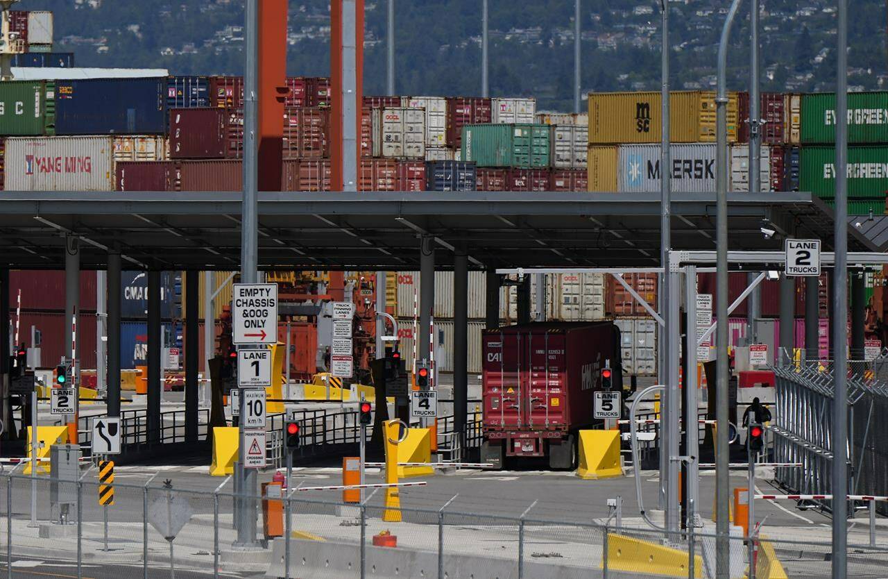 A transport truck carries a cargo container to the Centerm Container Terminal at port in Vancouver, on Friday, July 14, 2023. The uncertainty at British Columbia ports continues as the union representing about 7,400 workers and their employers remain without a deal in what one labour expert calls a "unprecedented" situation. THE CANADIAN PRESS/Darryl Dyck