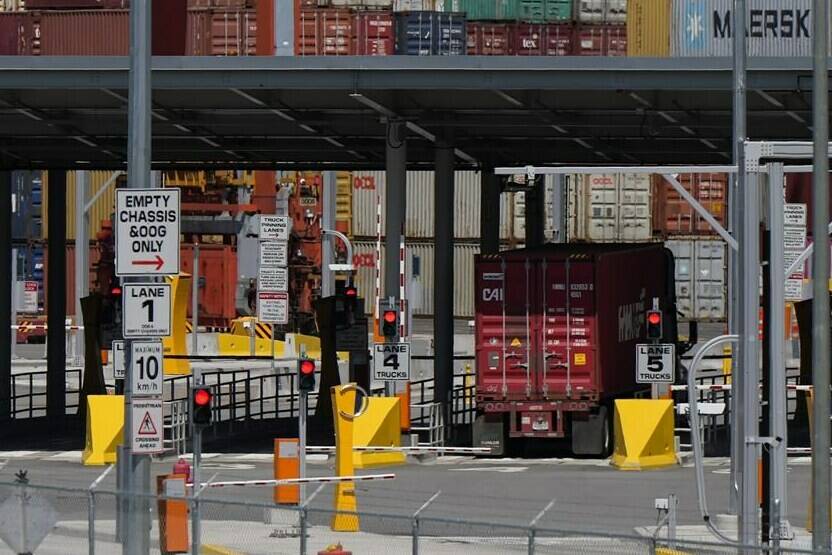 A transport truck carries a cargo container to the Centerm Container Terminal at port in Vancouver, on Friday, July 14, 2023. The uncertainty at British Columbia ports continues as the union representing about 7,400 workers and their employers remain without a deal in what one labour expert calls a “unprecedented” situation. THE CANADIAN PRESS/Darryl Dyck