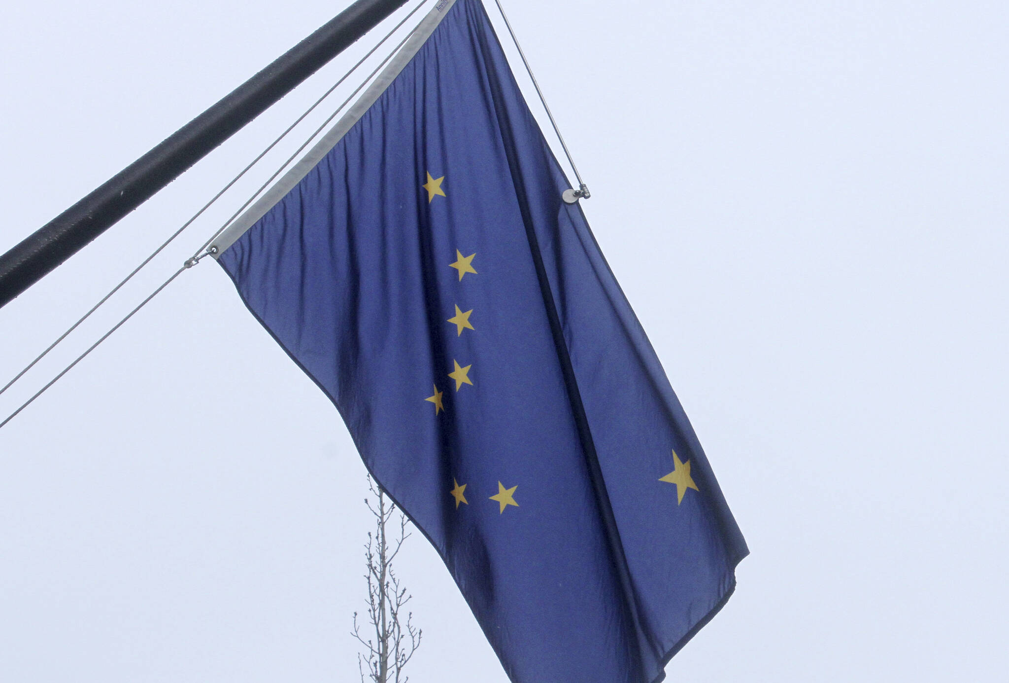 A state of Alaska flag flies outside the Atwood Building in downtown Anchorage, Alaska, on Friday, March 11, 2022. A rescue and recovery dive team was deployed Saturday (July 22) after a helicopter with a pilot and three state workers crashed in a large lake on Alaska’s North Slope, officials said. (AP Photo/Mark Thiessen)