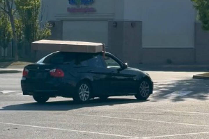 Two people were arrested in Nanaimo after driving off with a stolen 75-inch TV they placed on the roof of their car and held onto. (Photo submitted)