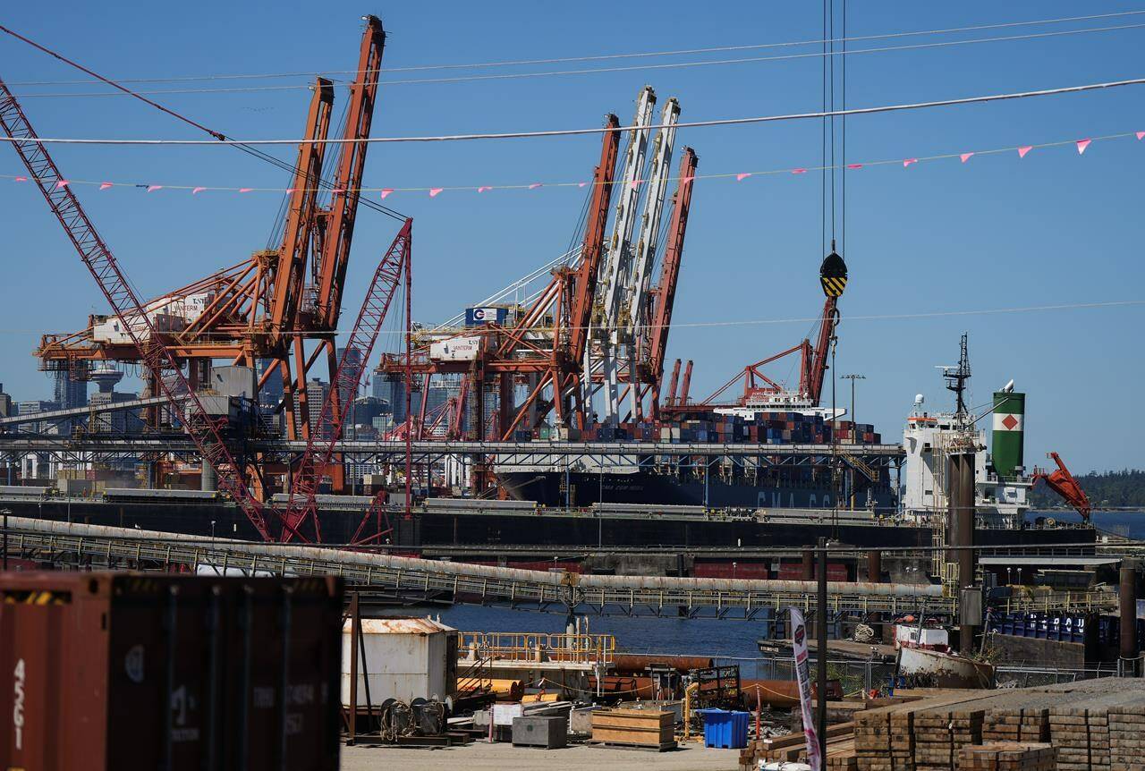 Gantry cranes sit idle as a container ship is docked at port during a work stoppage, in Vancouver, on Wednesday, July 19, 2023. THE CANADIAN PRESS/Darryl Dyck