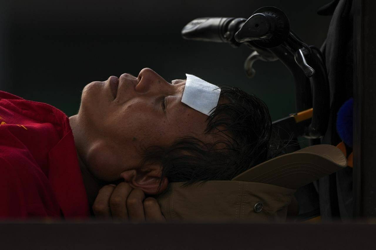 FILE - A man with a cooling pad on his forehead takes a nap on a bench on a sweltering day in Beijing, July 24, 2023. At about summer’s halfway point, the record-breaking heat and weather extremes are both unprecedented and unsurprising, hellish yet boring in some ways, scientists say. (AP Photo/Andy Wong, File)