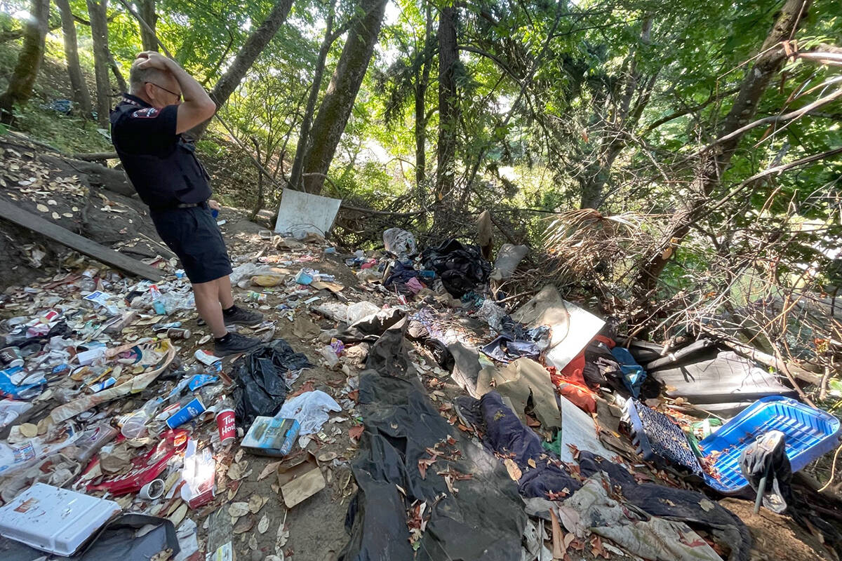 Wally Taylor, city bylaws officer, takes a look Tuesday, Aug. 1, at the clean-up work ahead at an encampment along the Millstone River. (Chris Bush/News Bulletin)