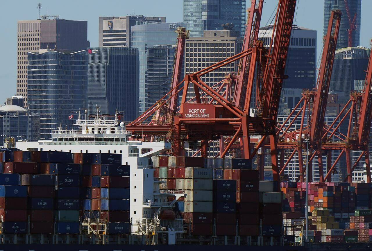 Gantry cranes sit idle as a container ship is docked at port during a work stoppage, in Vancouver, on Wednesday, July 19, 2023. Voting among British Columbia port workers on a new agreement with employers is scheduled to conclude today, with the result deciding whether the months-long labour dispute will end or continue. THE CANADIAN PRESS/Darryl Dyck