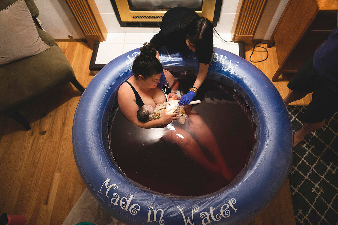 Midwife Terah Leah cuts the umbilical cord of a child of after a home birth. File photo courtesy Foothills Midwifery