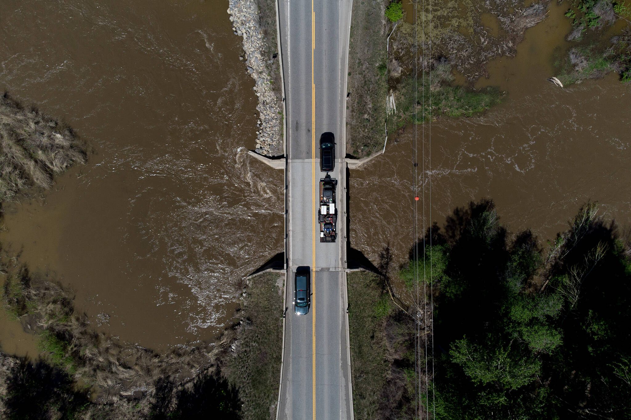 Motorists traveling on the Cariboo Highway cross a bridge over the swollen Bonaparte River, north of Cache Creek, B.C., on Sunday, May 14, 2023. Environment Canada says unseasonably hot temperatures in British Columbia will persist over the coming days, with special weather statements warning of high river streamflows due to melting snow in hard-hit communities in the province’s interior. THE CANADIAN PRESS/Darryl Dyck