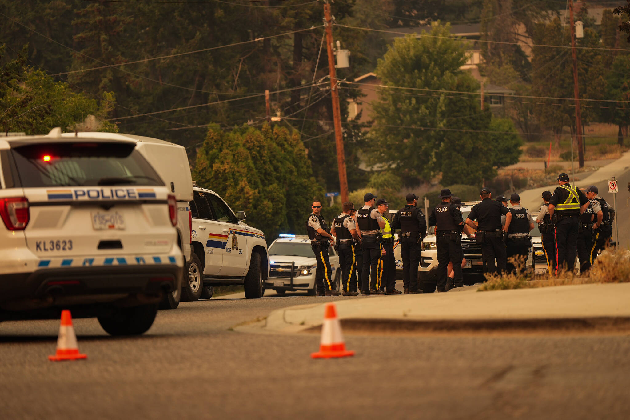 RCMP officers meet at a roadblock after evacuating the Wilden neighbourhood near Knox Mountain due to a wildfire burning above homes, in Kelowna, B.C., Friday, Aug. 18, 2023. THE CANADIAN PRESS/Darryl Dyck