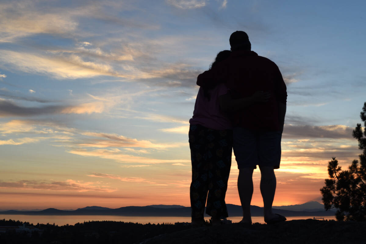 6:05 a.m. – Binita Gandhi (left) and Carson Clark watch the sunrise from the top of Mt. Tolmie. (Don Denton/Black Press Media)