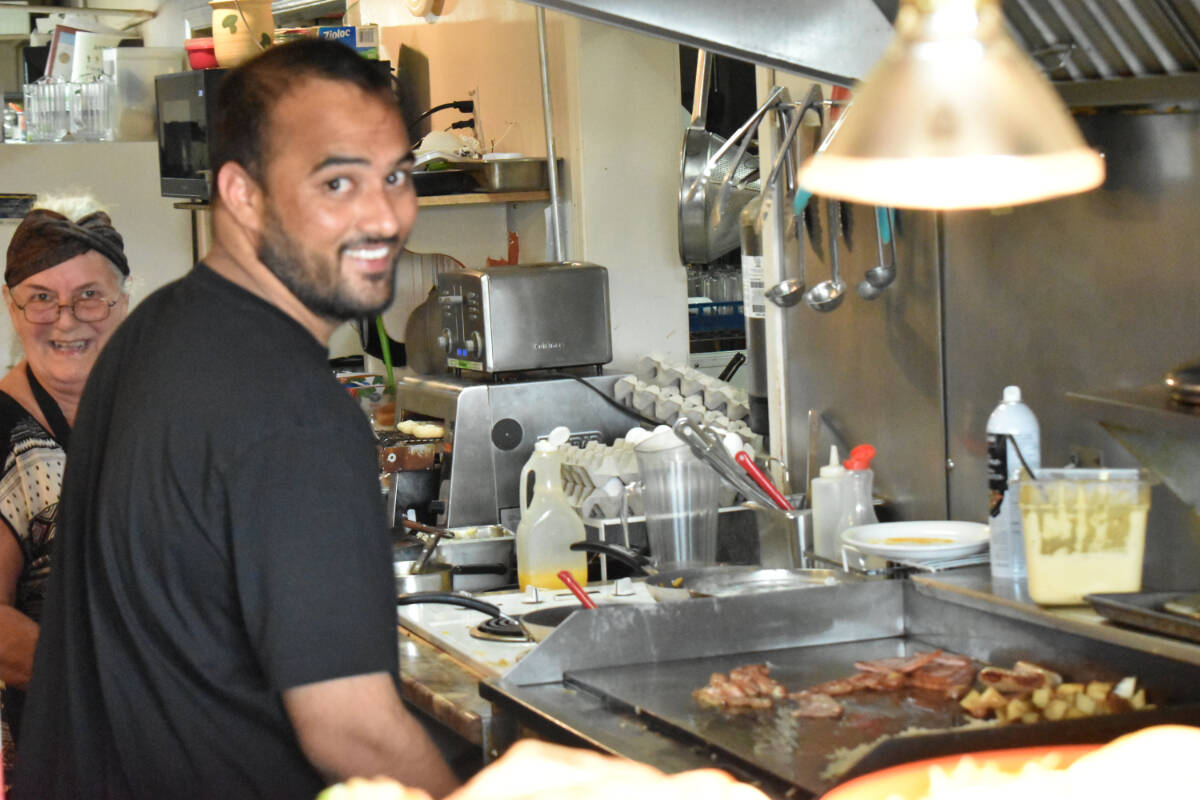 Pawan Saroop is behind the grill at Airpark Beachwood Cafe on Saturday, Aug. 26. He and his wife Sonia fear that their business will be soon displaced by development in the city. (Connor McDowell/Comox Valley Record)