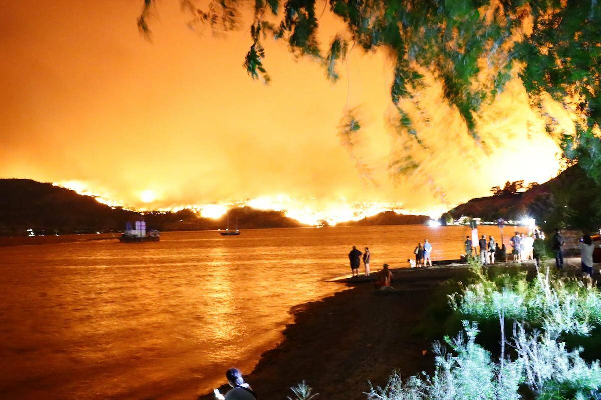Kelowna residents watch the McDougall Creek wildfire from the east side of Okanagan Lake as it lights up the night sky on Thursday, Aug. 17. (Contributed)