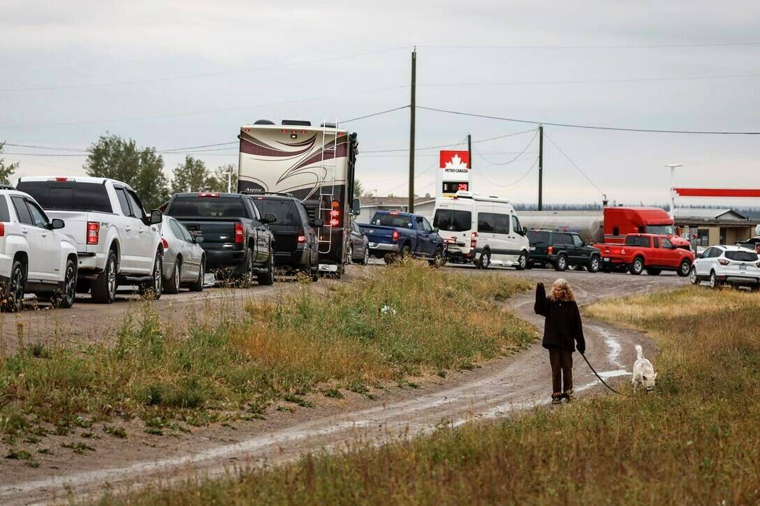 Vehicles line up for fuel at Fort Providence, N.W.T., on the only road south from Yellowknife, Thursday, Aug. 17, 2023. Fire-weary Northwest Territories is preparing for tens of thousands of people to return home after a much-needed win in the battle against a blaze that was threatening Yellowknife. THE CANADIAN PRESS/Jeff McIntosh