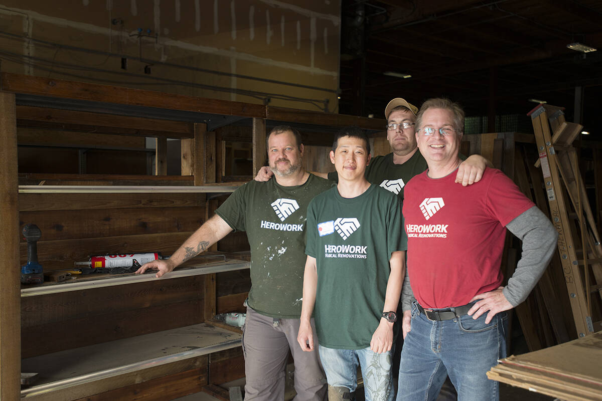 HeroWork executive director Paul Latour (right) in the warehouse with HeroWork volunteers finishing shelves for the Mustard Seed food bank. (News files)