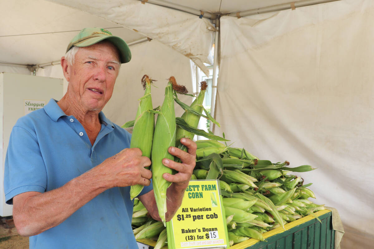 Larry Sluggett shows off some freshly picked corn. (Photo by Tim Collins)