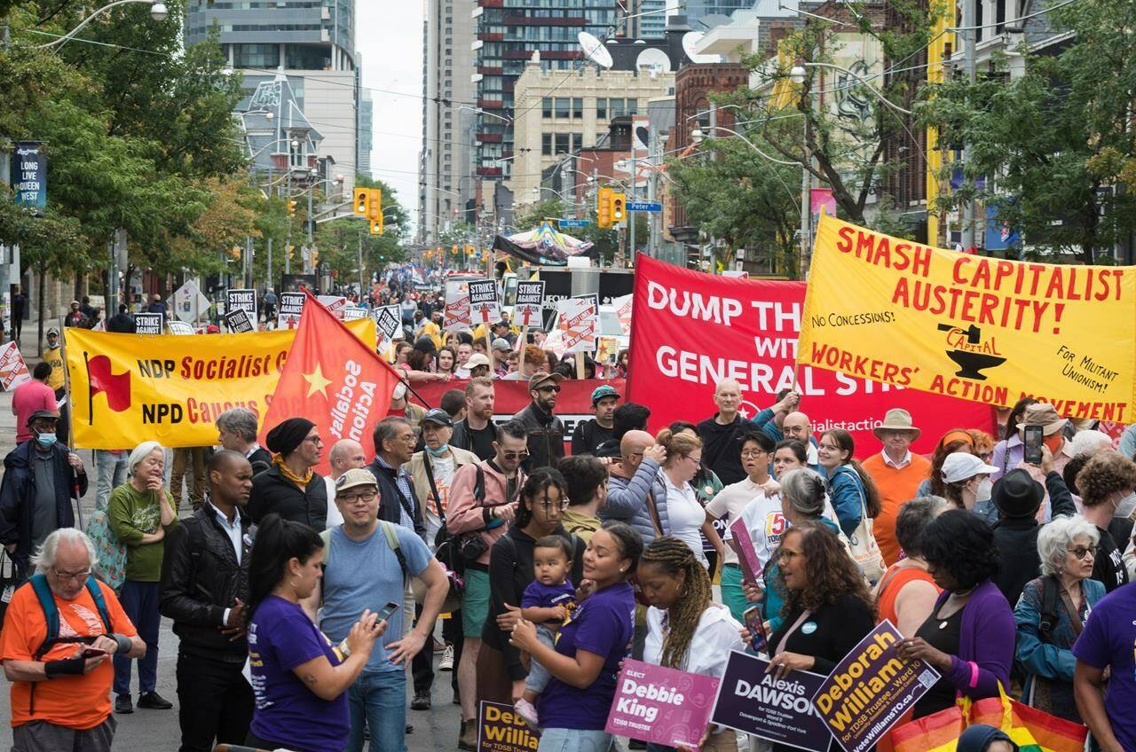 Union members and activist take part in the Labour Day Parade in Toronto, on Sept. 5, 2022. A record labour shortage and rising wages may seem like good news for workers, but labour leaders say workers aren’t seeing the gains that corporations are experiencing amidst sky-high inflation. THE CANADIAN PRESS/ Tijana Martin
