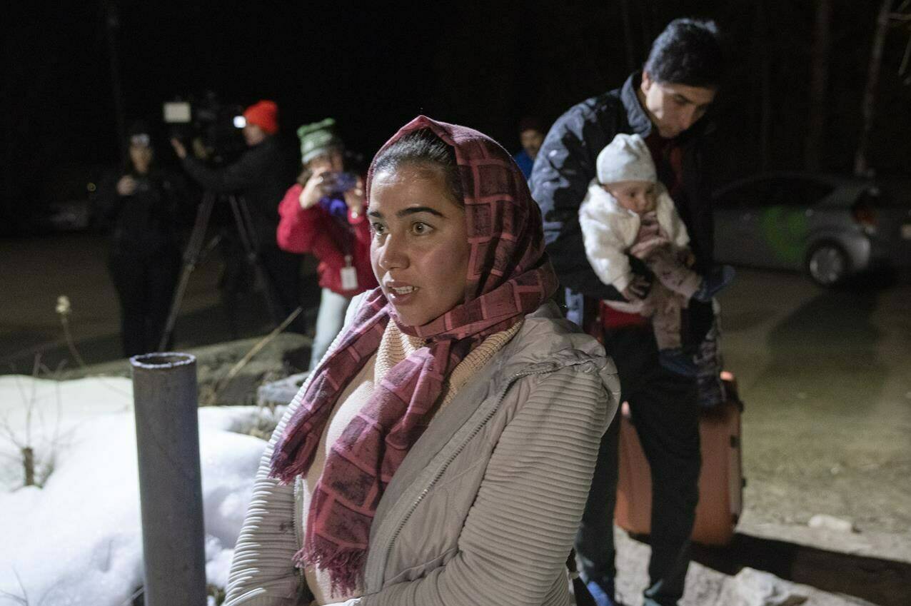Asylum seeker Taiba Nuri is followed by her husband Mahamed Yusef Niazi, from Afghanistan, carrying their seven-month-old daughter Sahaba, cross the border at Roxham Road from New York into Canada Friday March 24, 2023 in Champlain, NY.. The federal government plans to fight allegations of discrimination for the disparate way it approached the Ukrainian and Afghan refugee crises on a single legal front, as another Canadian-Afghan sues for the right to rescue their family from the Taliban.THE CANADIAN PRESS/Ryan Remiorz