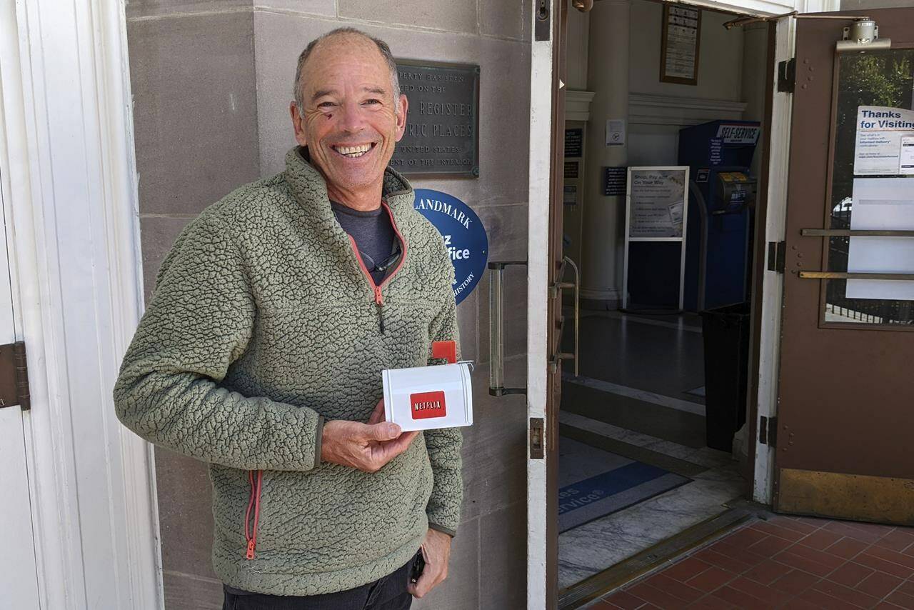 File - Netflix’s first CEO, Marc Randolph, poses outside the Santa Cruz, California, post office in May, 2022, where he had mailed a Patsy Cline CD to the company’s co-founder Reed Hastings, to test whether a disc could make it through the mail. The Netflix DVD-by-service will mail out its final discs Friday from its five remaining distribution centers, ending its 25-year history. (AP Photo/Mike Liedtke, File)