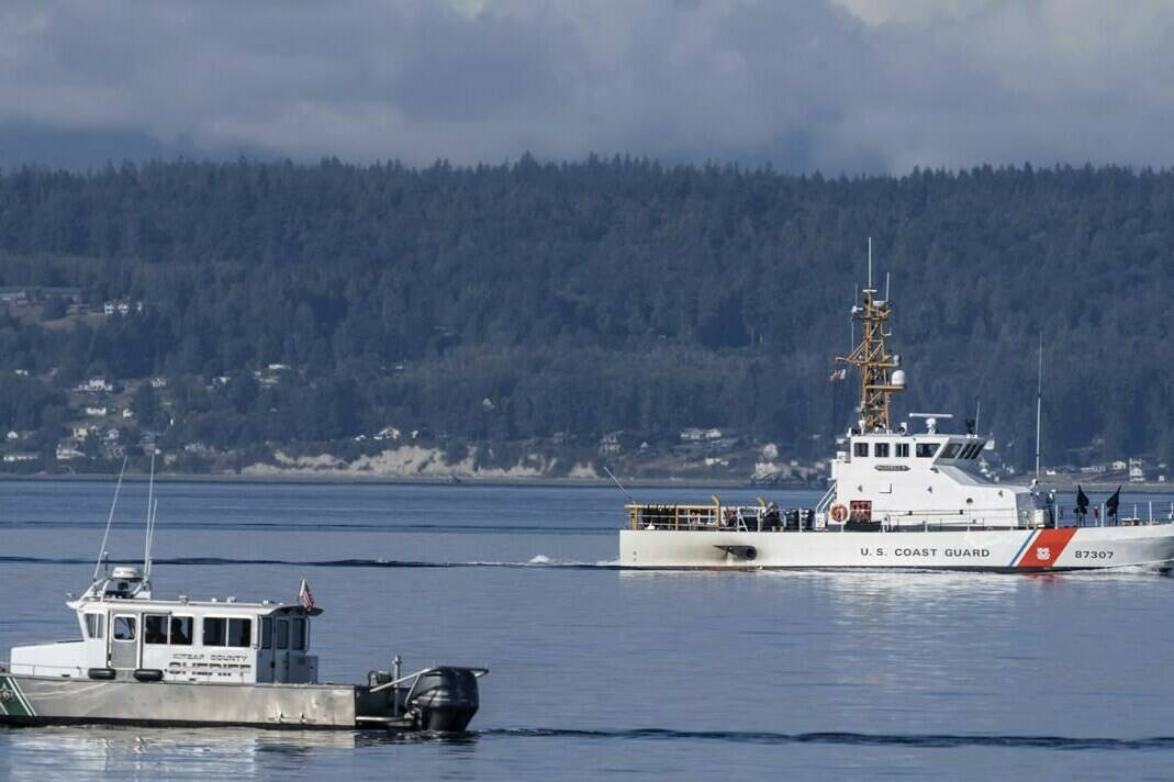 FILE - A U.S. Coast Guard boat and Kitsap, Wash., County Sheriff boat search an area, Monday, Sept. 5, 2022, near Freeland, Wash., on Whidbey Island north of Seattle where a chartered floatplane crashed the day before, killing 10 people. On Thursday, Oct. 5, 2023, the National Transportation Safety Board confirmed that a mechanical issue caused the seaplane to crash. (AP Photo/Stephen Brashear, File)