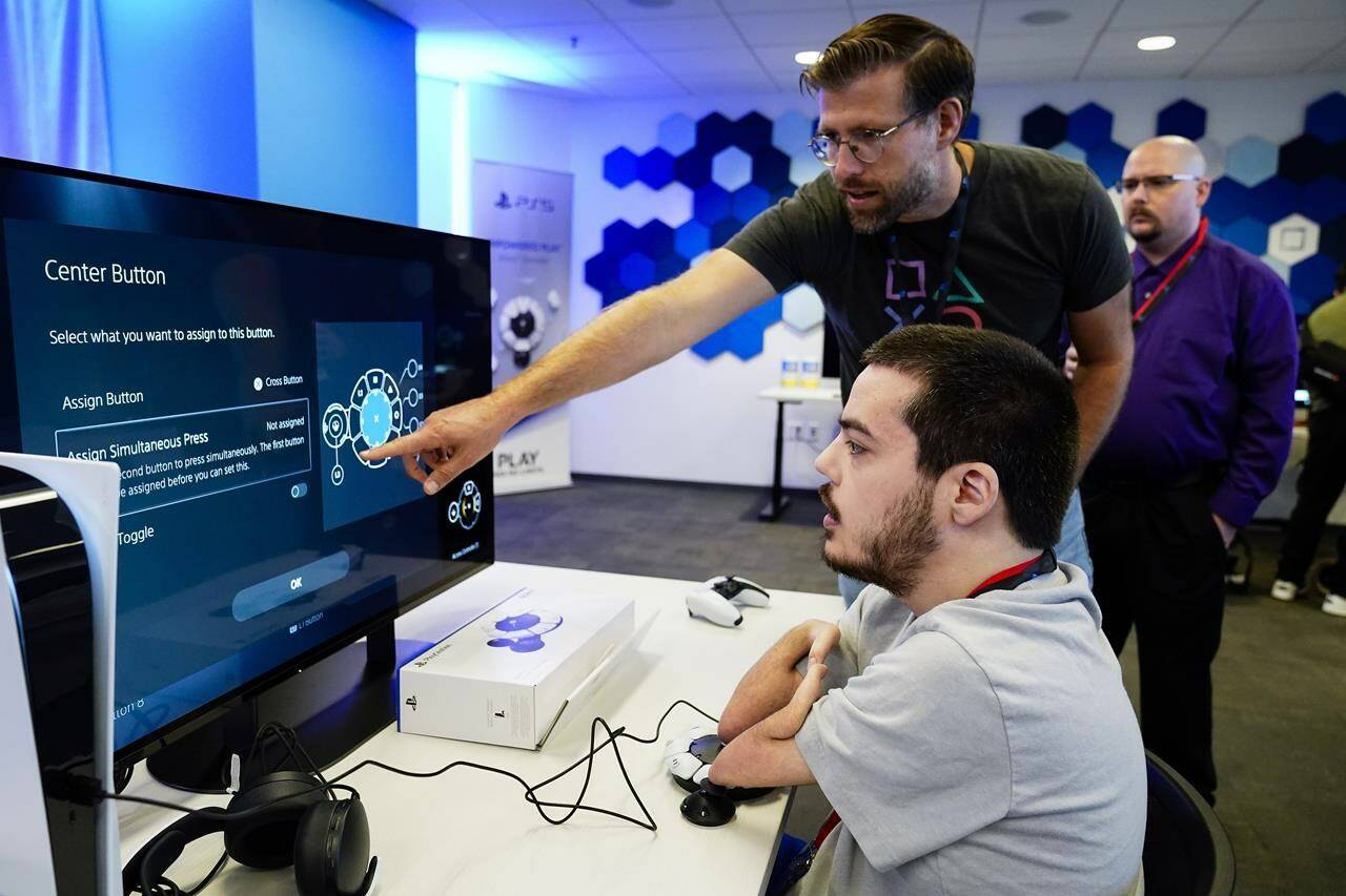 Martin Shane, right, customizes the button layout on the Sony Access controller before playing a video game at Sony Interactive Entertainment headquarters Thursday, Sept. 28, 2023, in San Mateo, Calif. (AP Photo/Godofredo A. Vásquez)