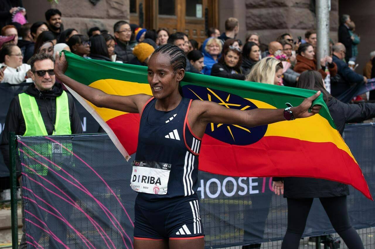 Women’s full marathon winner Ethiopia’s Buze Diriba poses for photos at the finish line for the TCS Toronto Waterfront Marathon in Toronto on Sunday, Oct. 15, 2023. THE CANADIAN PRESS/Jessica Lee