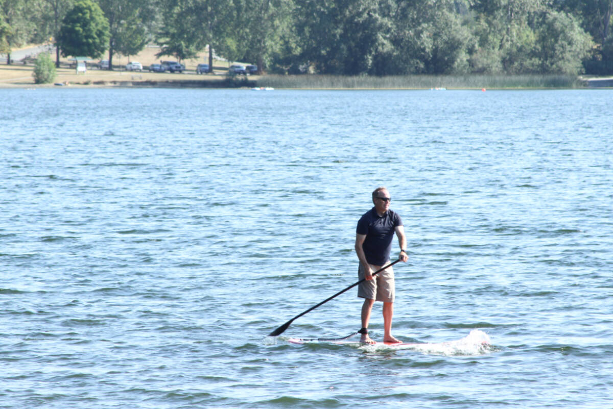 A stand-up paddleboarder powers through the water at Elk Lake. (Katherine Engqvist/News Staff)