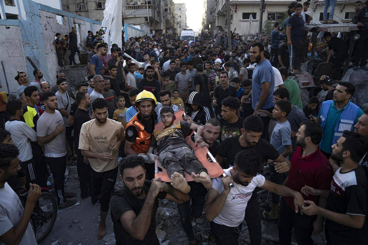 Palestinians carry an injured person on a stretcher after an airstrike in Khan Younis, Gaza Strip, Saturday, Oct. 21, 2023. The Canadian government announced Saturday it will provide an additional $50 million for humanitarian assistance in the Gaza Strip as the region’s border crossing with Egypt opened to let a trickle of desperately needed aid into the besieged Palestinian territory. THE CANADIAN PRESS/AP/Fatima Shbair