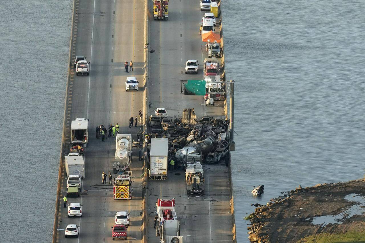 In this aerial photo, responders are seen near wreckage in the aftermath of a multi-vehicle pileup on I-55 in Manchac, La., Monday, Oct. 23, 2023. A “superfog” of smoke from south Louisiana marsh fires and dense morning fog caused multiple traffic crashes involving scores of cars. (AP Photo/Gerald Herbert)