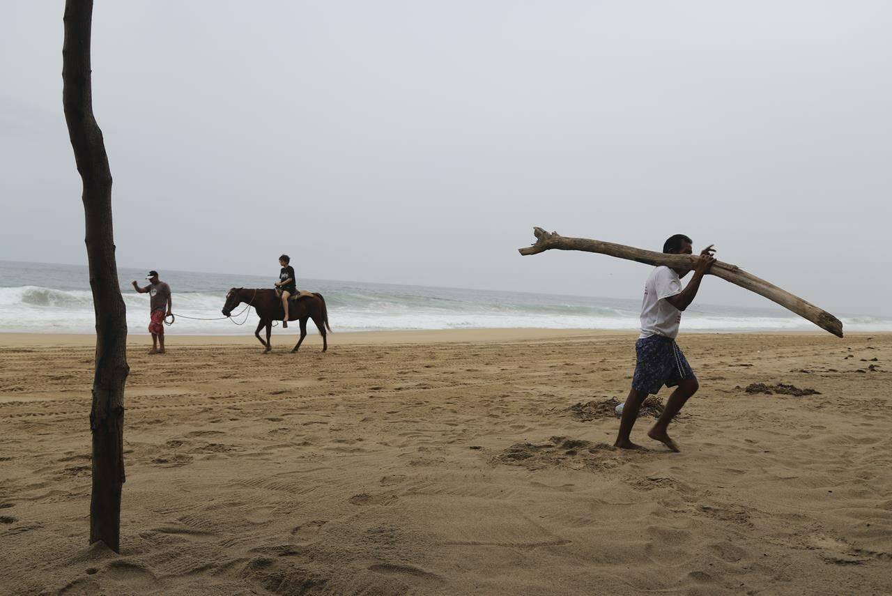 A tourist rides a horse at a beach in Acapulco, Mexico, Tuesday, Oct. 24, 2023. Hurricane Otis has strengthened from tropical storm to a major hurricane in a matter of hours as it approaches Mexico’s southern Pacific coast where it was forecast to make landfall near the resort of Acapulco early Wednesday. (AP Photo/Bernardino Hernandez)