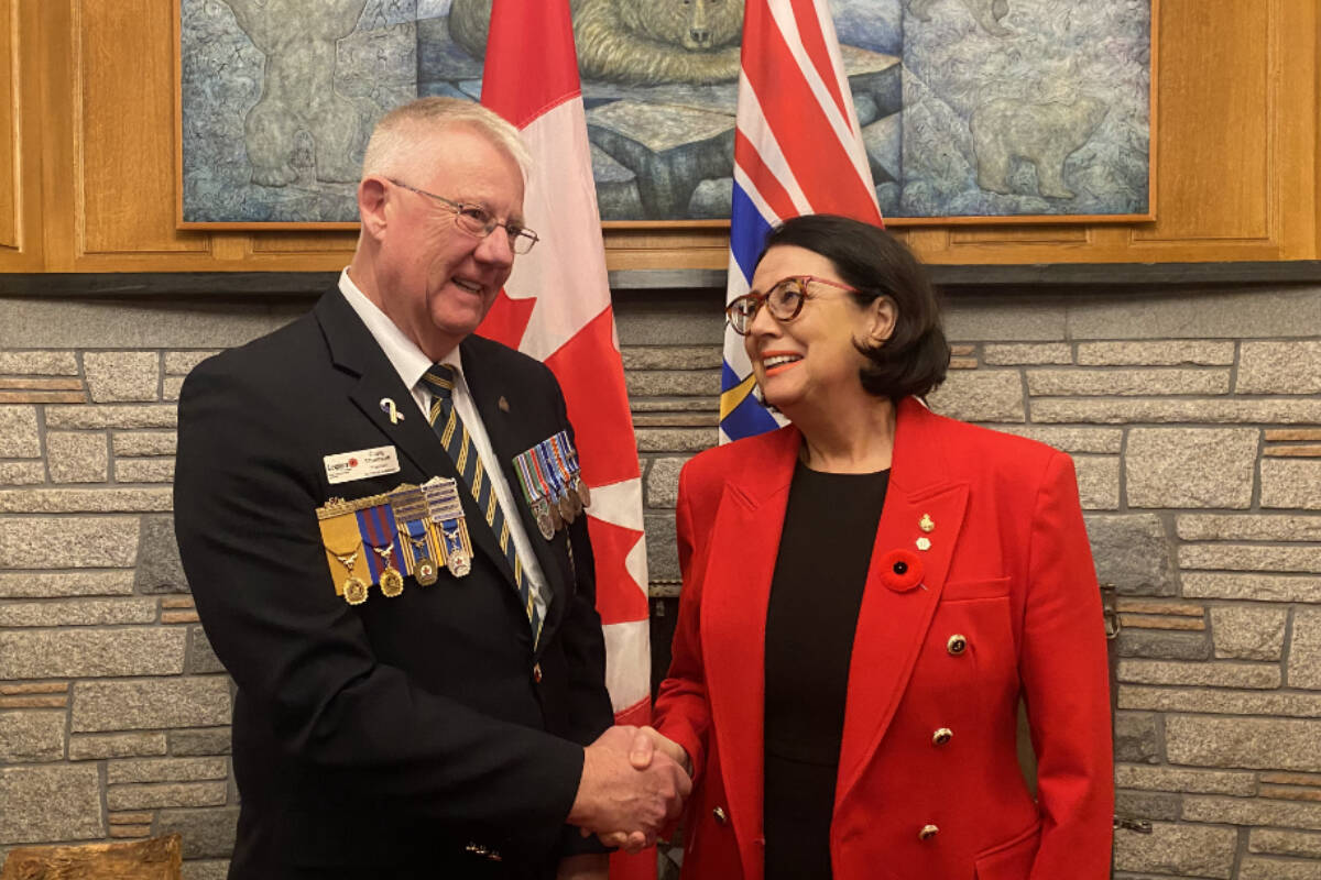 Craig Thompson, president of the Royal Canadian Legion B.C./Yukon Command, shakes hands with Lt.-Gov. Janet Austin after he presented her with the first poppy of the 2023 poppy campaign. (Ella Matte/News Staff)