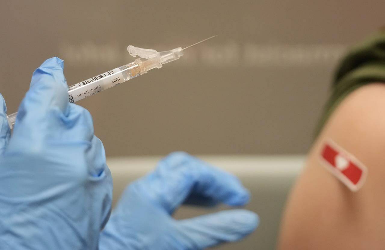 Doctors say it’s important to get the updated version of the COVID-19 vaccine, which offers protection against the XBB.1.5 subvariant driving a current rise in cases. A pharmacist prepares to administer a Moderna Spikevax COVID-19 vaccine at a CVS, Wednesday, Sept. 20, 2023, in Cypress, Texas. THE CANADIAN PRESS/Melissa Phillip-Houston Chronicle via AP