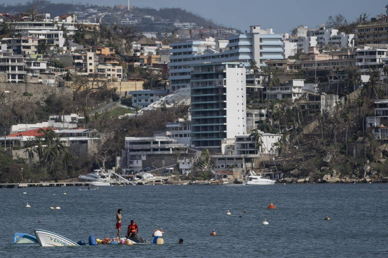 Fishermen try to rescue sunken boats in the aftermath of Hurricane Otis in Acapulco, Mexico, Saturday, Oct. 28, 2023. (AP Photo/Felix Marquez)