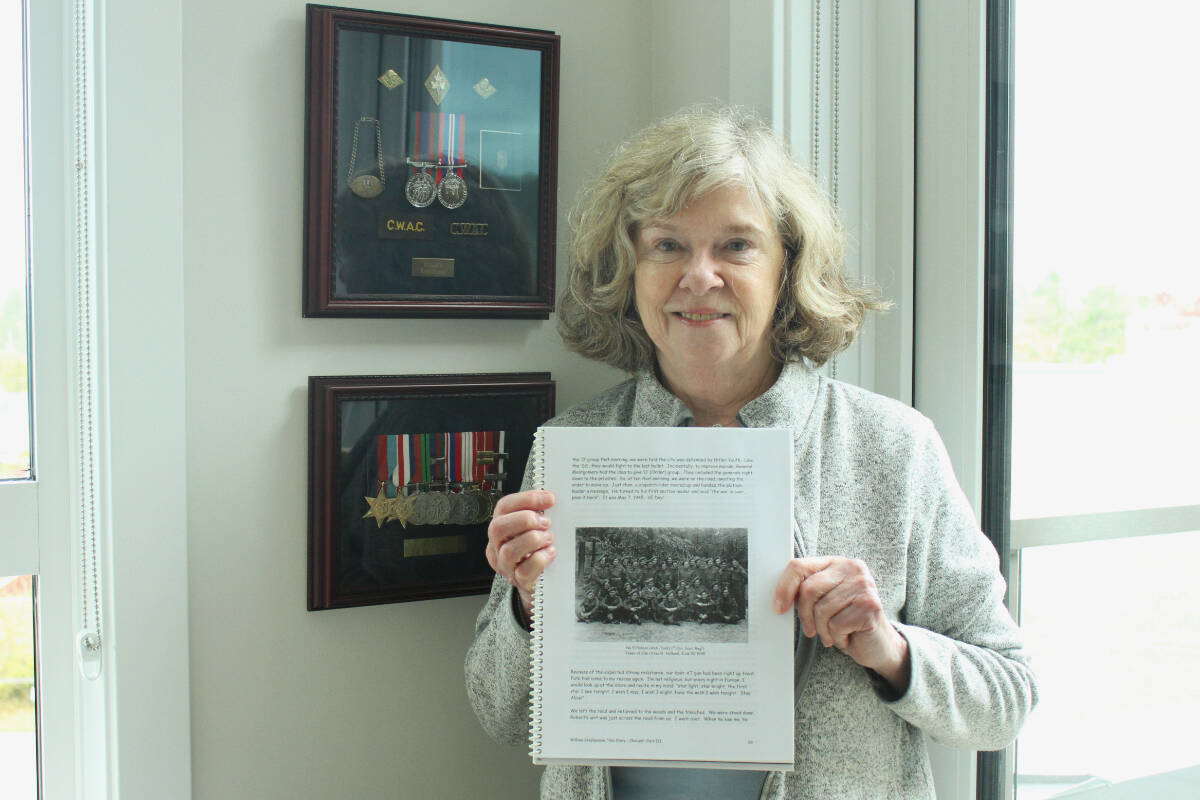 Standing in front of her father’s medals and holding up his autobiography that focuses on his time in the army, Elizabeth Macrae recalls how it was a struggle for her parents to get the support they needed after serving (her mother was also a decoder in the army). Macrae is the president of the Victoria - Fred Whitehouse Branch at the National Association of Federal Retirees. (Samantha Duerksen/BlackPress Media)
