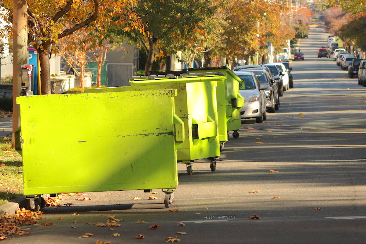 Garbage bins line a Victoria street in October. The CRD will evaluate making it mandatory that all of its 13 communities have some form of curbside green bin collection. (Jake Romphf/News Staff)